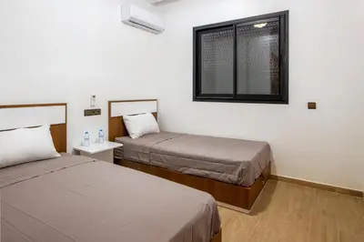 a hotel room with two beds and a window at Heart of Marrakech - Hivernage 2 bedroom apartment in Marrakech