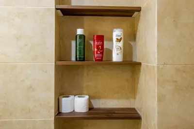a shelf in a bathroom with toiletries on it at Heart of Marrakech - Hivernage 2 bedroom apartment in Marrakech