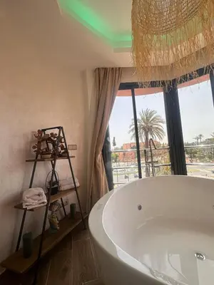 a bath tub in a bathroom with a large window at Central nest romantic stay in Marrakech