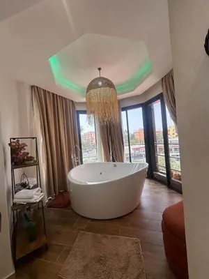 a large white tub in a bathroom with windows at Central nest romantic stay in Marrakech