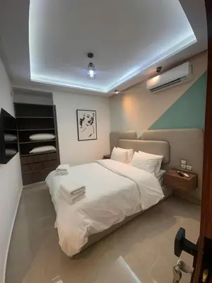a bedroom with a large bed with white sheets at Central nest romantic stay in Marrakech
