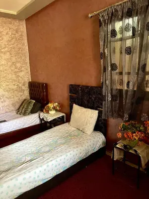 a bedroom with two beds and a table with flowers at luxery in Aït Bou Setta