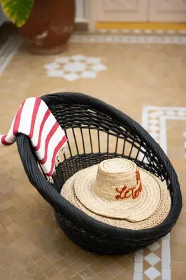 a straw hat in a basket with a sombrero at Riad Le Terracotta in Marrakech
