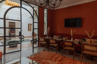 a dining room with a table and chairs and a tv at Riad Le Terracotta in Marrakech