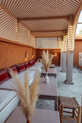 a room with tables and chairs with pampas grass at Riad Le Terracotta in Marrakech