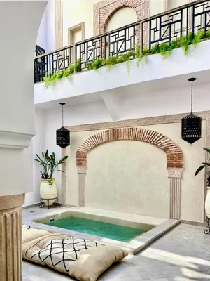 a swimming pool in a building with an archway and a swimming poolvisorvisor at Riad Madame Riad privé à deux pas de la Place Jemaa El Fna in Marrakech