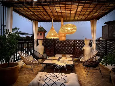 a patio with a table and chairs and a chandelier at Riad Madame Riad privé à deux pas de la Place Jemaa El Fna in Marrakech