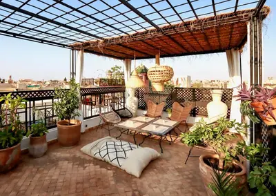 a balcony with a table and chairs and plants at Riad Madame Riad privé à deux pas de la Place Jemaa El Fna in Marrakech