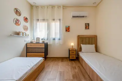 a bedroom with two beds and a window and a dresser at Urban Dream piscine et central in Marrakech