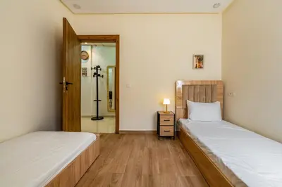 two beds in a room with a mirror at Urban Dream piscine et central in Marrakech