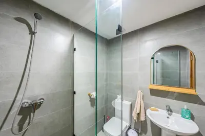 a bathroom with a shower and a toilet and a sink at Urban Dream piscine et central in Marrakech