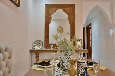 a dining room with a table and a mirror at DarKech luxury and comfort in Marrakech