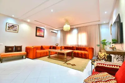 a living room with orange couches and a table at DarKech luxury and comfort in Marrakech