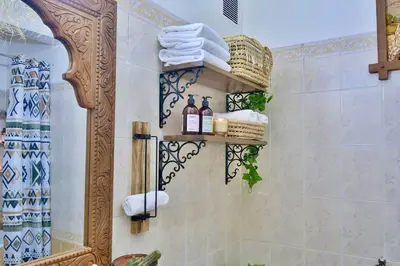 a bathroom with a shower with towels and a mirror at DarKech luxury and comfort in Marrakech