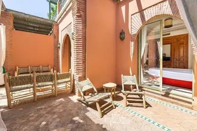 a patio with chairs and a tub in a building at La Palmeraie 2BR Garden & Pool in Marrakech