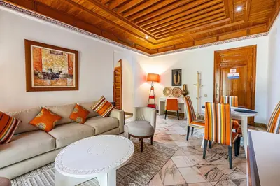 a living room with a couch and a table at La Palmeraie 2BR Garden & Pool in Marrakech