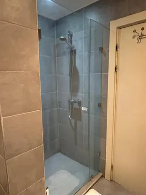 a bathroom with a shower with a glass door at Appartement moderne proximité Carré Eden Marrakech in Marrakech