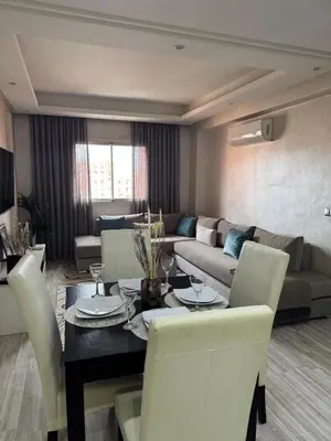 a living room with a table and a couch at Appartement moderne proximité Carré Eden Marrakech in Marrakech