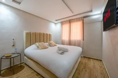 a bedroom with a large white bed and a window at Marrakech Duplex Spacieux avec Terrasse in Marrakech