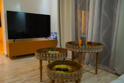two tables in a living room with a television at duplex a Gueliz in Marrakech