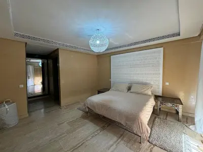 a bedroom with a large bed and a chandelier at duplex a Gueliz in Marrakech