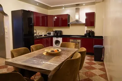 a kitchen with a table and chairs and a kitchen with red cabinets at duplex a Gueliz in Marrakech