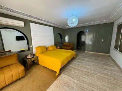 a bedroom with a yellow bed and a couch at duplex a Gueliz in Marrakech