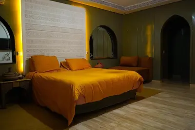 a bedroom with a large bed and a chair at duplex a Gueliz in Marrakech