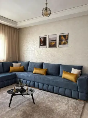 a living room with a blue couch and a table at Appartement refait à neuf in Marrakech