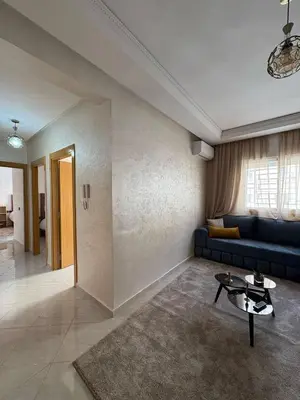 a living room with a couch and a table at Appartement refait à neuf in Marrakech