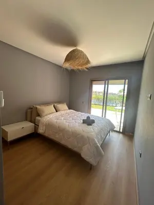 a bedroom with a large bed and a large window at Relax appartement in Marrakech