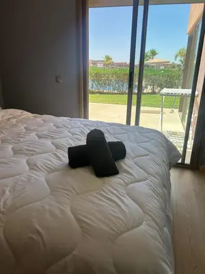 a white bed with a black cross on top of it at Relax appartement in Marrakech