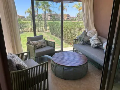 a living room with chairs and a table and a window at Relax appartement in Marrakech