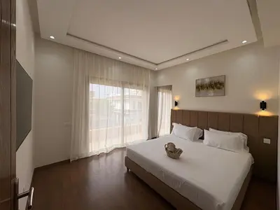a bedroom with a large bed with a large window at Villa del Sur 5 min du centre in Marrakech