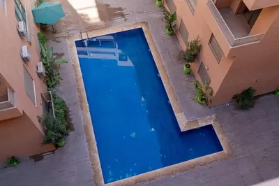 an overhead view of a swimming pool between two buildings at Écrin Soleil proche Guéliz et sécurisé in Marrakech