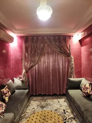 a living room with two couches and a curtain at Comfortable apartment for families in Marrakech