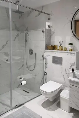 a white bathroom with a shower and a toilet at Rahma Apartment in Marrakech