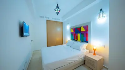 a bedroom with a white bed and a tv at Chic City Studio in Marrakech in Marrakech