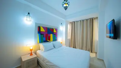 a bedroom with a white bed and a blue light at Chic City Studio in Marrakech in Marrakech