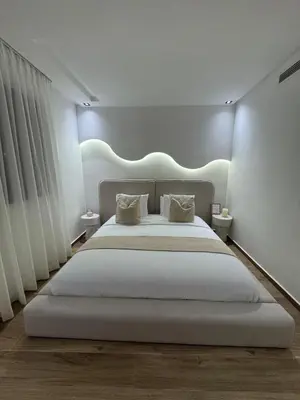 a bedroom with a large white bed with lights on it at Menara Garden - 3 Ch - Piscine - 2 min de M Avenue in Marrakech