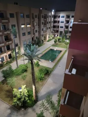 an apartment building with a pool and palm tree at Modern Apartment with Pools & Free Parking in Marrakech