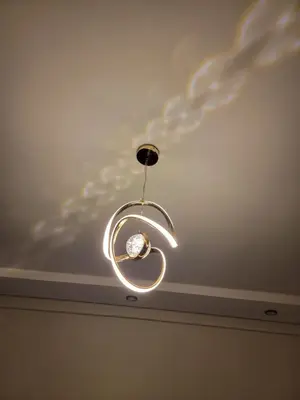 a light fixture hanging from a ceiling with clouds on the ceiling at Modern Apartment with Pools & Free Parking in Marrakech