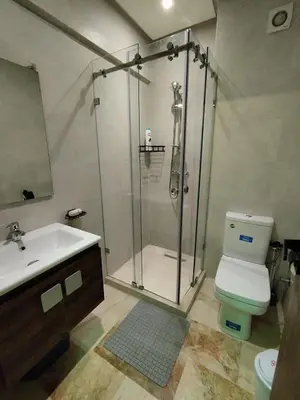 a bathroom with a shower and a toilet and a sink at Modern Apartment with Pools & Free Parking in Marrakech