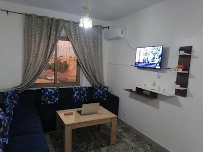 a living room with a blue couch and a tv at Menara Airport Appartement - 10 Min Walk in Marrakech