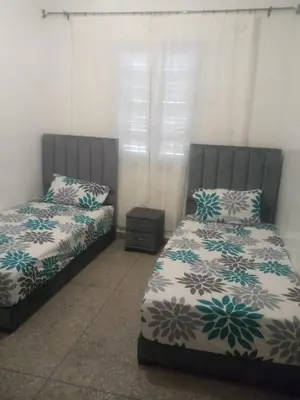 two beds sitting next to each other in a bedroom at Menara Airport Appartement - 10 Min Walk in Marrakech