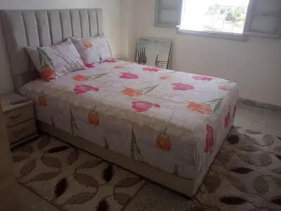 a bedroom with a bed with pink flowers on it at Menara Airport Appartement - 10 Min Walk in Marrakech