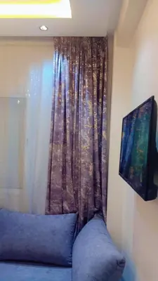 a room with a window with a blue couch and a television at Appartement,kech in Marrakech