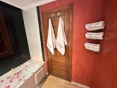 a bathroom with a shower and a tub and towels at Appartement de Luxe avec Piscine et Jacuzzi Marrakech in Marrakech