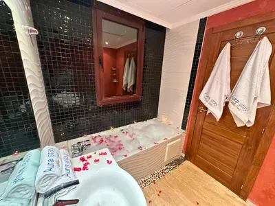 a bathroom with a sink and a bath tub at Appartement de Luxe avec Piscine et Jacuzzi Marrakech in Marrakech
