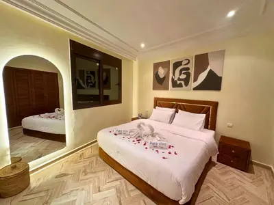 a bedroom with two beds with red flowers on them at Appartement de Luxe avec Piscine et Jacuzzi Marrakech in Marrakech